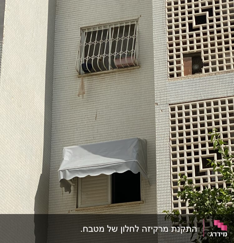 סוכך אפור מותקן מעל חלון בניין